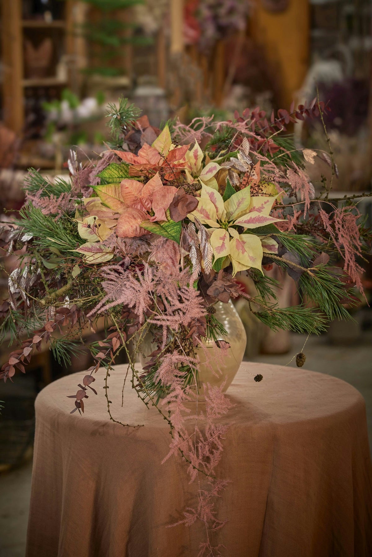 Large autumn pedestal arrangement on a linen-covered table