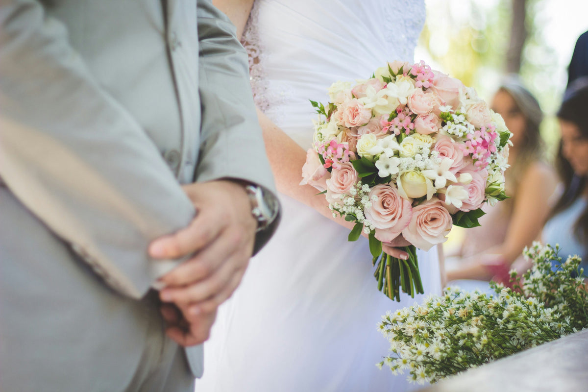 Bride holding a blush pink rose bouquet at the ceremony