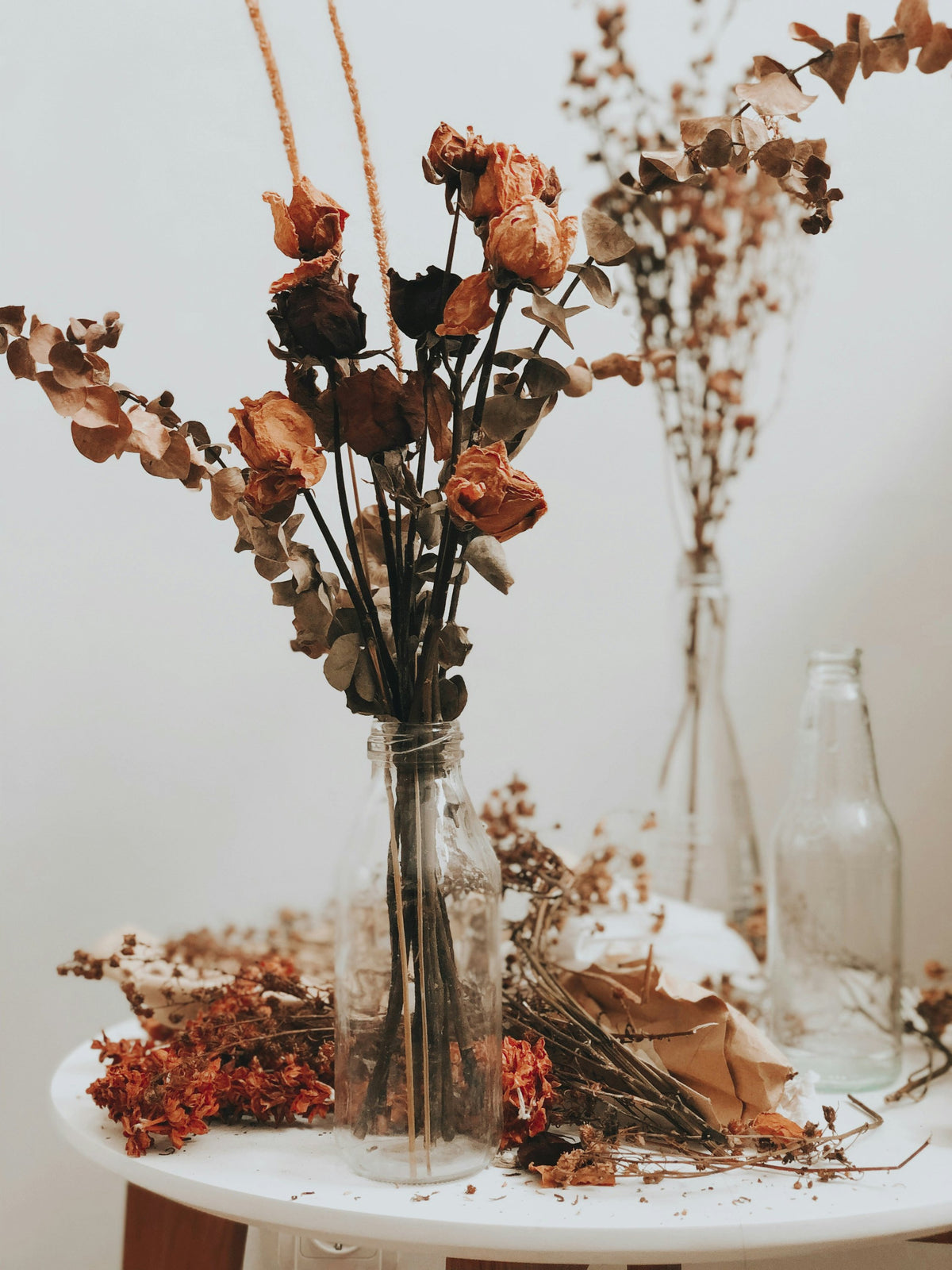 Dried roses and grasses in glass bottles