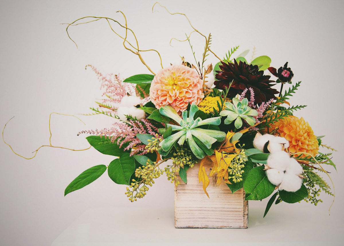 Large arrangement of dahlias, succulents and astilbe in a wooden box