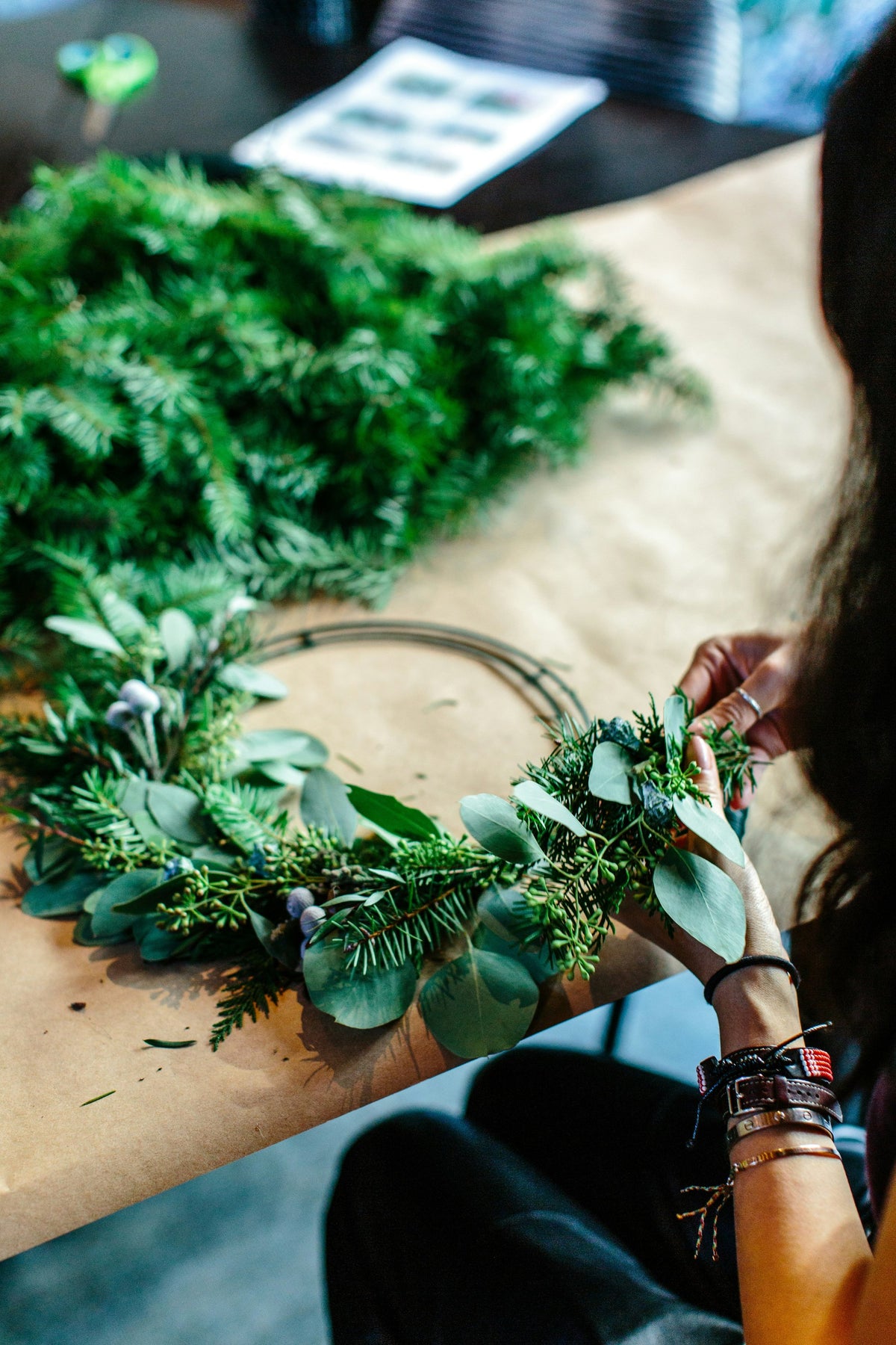 Workshop guest wiring foliage onto a wreath frame